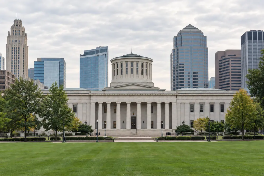 The Ohio Statehouse in downtown Columbus with the city skyline behind it