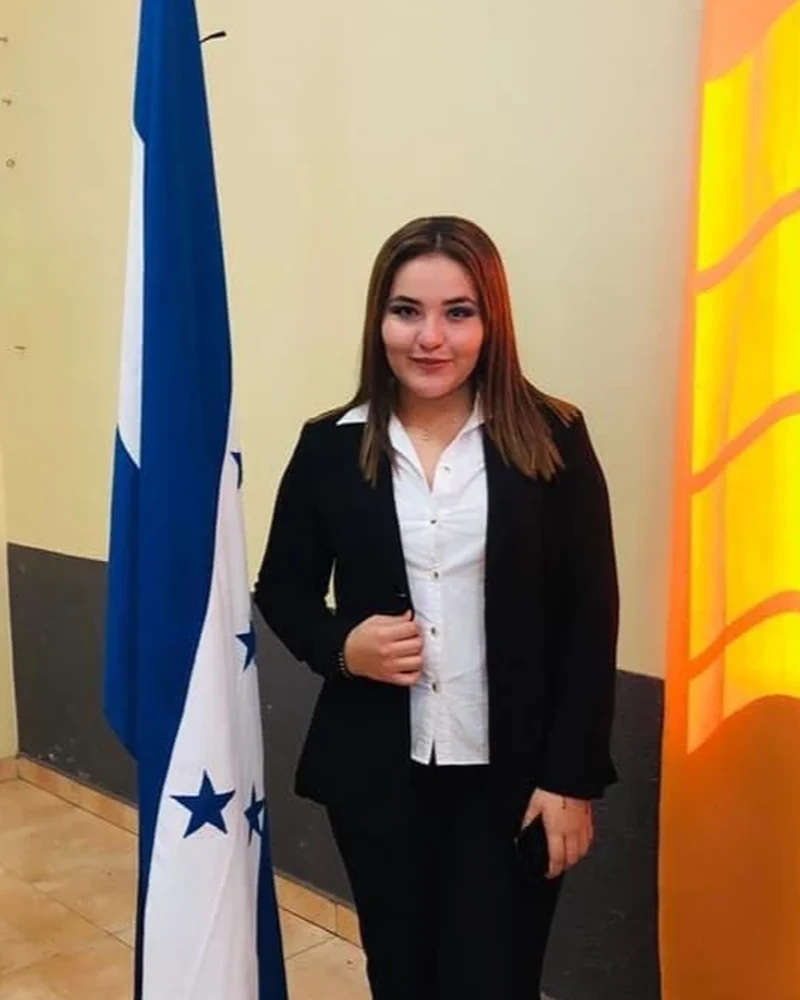 Linda Bond, Bond Enterprise Language Services founder, standing with the Honduran flag.